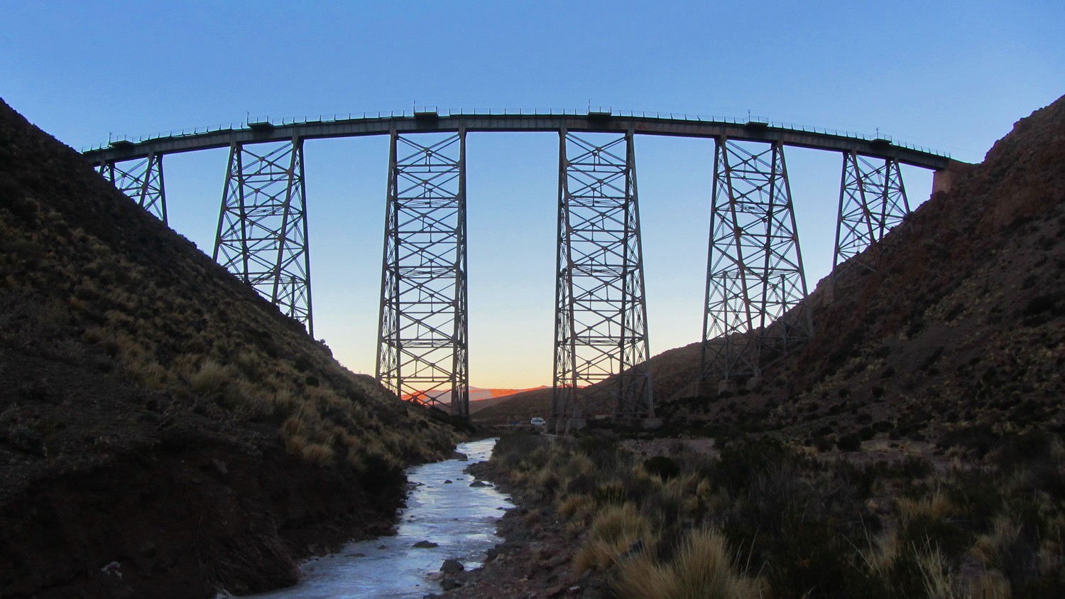 Railway bridge Viaducto La Polvorilla 20 km West of San Antonio de los Cobres with frozen stream at sunrise